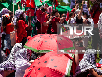 People take shelter from the sun under watermelon umbrellas during a pro-Palestinian protest at the White House, Washington, DC, June 8, 202...