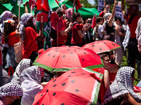 People take shelter from the sun under watermelon umbrellas during a pro-Palestinian protest at the White House, Washington, DC, June 8, 202...