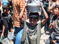 Palestinians are queuing for meal rations at a communal food distribution point in Deir al-Balah in the besieged Gaza Strip on June 10, 2024...