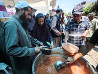 Palestinians are queuing for meal rations at a communal food distribution point in Deir al-Balah in the besieged Gaza Strip on June 10, 2024...