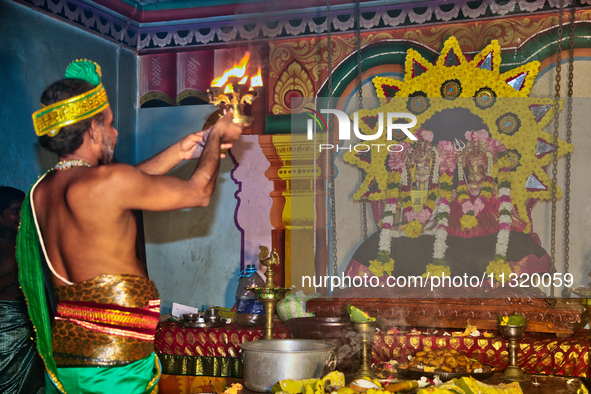 A Tamil Hindu priest is performing special prayers during the 10th night of the Pathirakali Amman festival at the Pathirakali Amman Kovil (P...