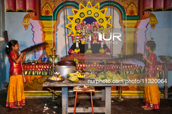 Tamil Hindu girls are using fans made of peacock feathers to fan the deities during the 10th night of the Pathirakali Amman festival at the...