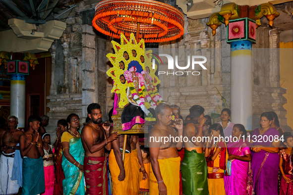 Tamil Hindu devotees are carrying the deities from the temple to the chariot outside during the 10th night of the Pathirakali Amman festival...