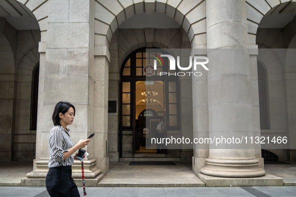 A woman is walking past the entrance of the Court of Final Appeal in Hong Kong, on June 11, 2024. 