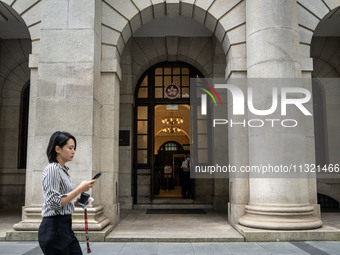 A woman is walking past the entrance of the Court of Final Appeal in Hong Kong, on June 11, 2024. (