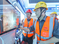 Workers are simulating the operation of an electric welding machine in Huzhou, China, on June 11, 2024. (