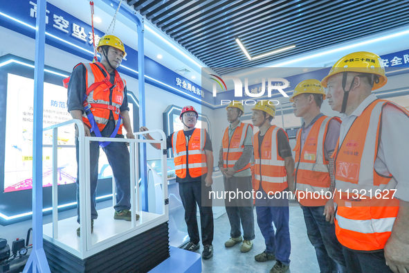 Workers are performing a high-altitude fall experience in Huzhou, China, on June 11, 2024. 