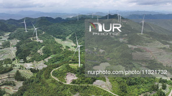 Wind turbines are being seen on a mountain in Qishe township in Xingyi city, Guizhou province, China, on June 11, 2024. 