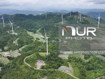 Wind turbines are being seen on a mountain in Qishe township in Xingyi city, Guizhou province, China, on June 11, 2024. (