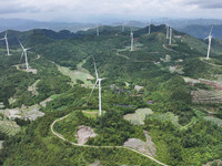 Wind turbines are being seen on a mountain in Qishe township in Xingyi city, Guizhou province, China, on June 11, 2024. (