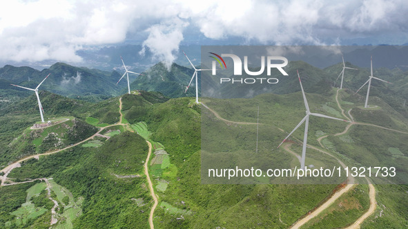 Wind turbines are being seen on a mountain in Qishe township in Xingyi city, Guizhou province, China, on June 11, 2024. 