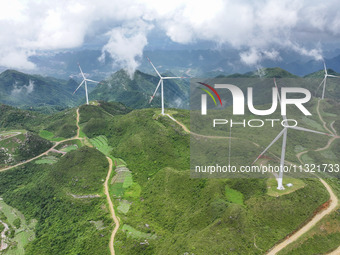 Wind turbines are being seen on a mountain in Qishe township in Xingyi city, Guizhou province, China, on June 11, 2024. (