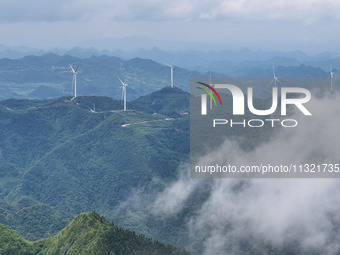 Wind turbines are being seen on a mountain in Qishe township in Xingyi city, Guizhou province, China, on June 11, 2024. (