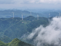 Wind turbines are being seen on a mountain in Qishe township in Xingyi city, Guizhou province, China, on June 11, 2024. (