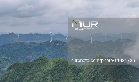 Wind turbines are being seen on a mountain in Qishe township in Xingyi city, Guizhou province, China, on June 11, 2024. 