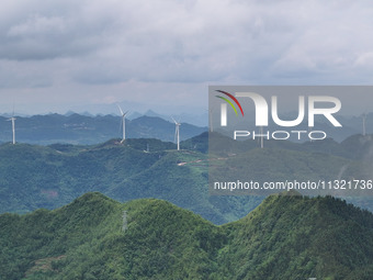 Wind turbines are being seen on a mountain in Qishe township in Xingyi city, Guizhou province, China, on June 11, 2024. (