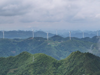 Wind turbines are being seen on a mountain in Qishe township in Xingyi city, Guizhou province, China, on June 11, 2024. (