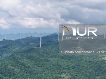 Wind turbines are being seen on a mountain in Qishe township in Xingyi city, Guizhou province, China, on June 11, 2024. (