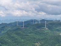 Wind turbines are being seen on a mountain in Qishe township in Xingyi city, Guizhou province, China, on June 11, 2024. (