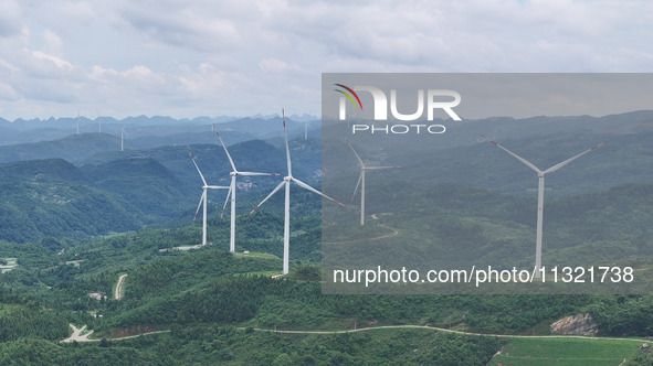 Wind turbines are being seen on a mountain in Qishe township in Xingyi city, Guizhou province, China, on June 11, 2024. 