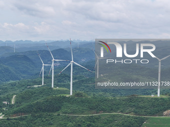 Wind turbines are being seen on a mountain in Qishe township in Xingyi city, Guizhou province, China, on June 11, 2024. (