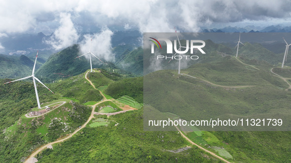 Wind turbines are being seen on a mountain in Qishe township in Xingyi city, Guizhou province, China, on June 11, 2024. 