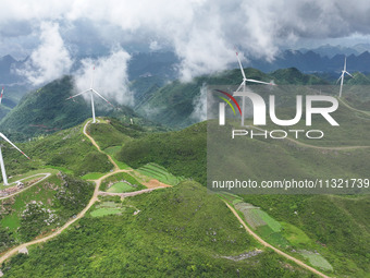 Wind turbines are being seen on a mountain in Qishe township in Xingyi city, Guizhou province, China, on June 11, 2024. (