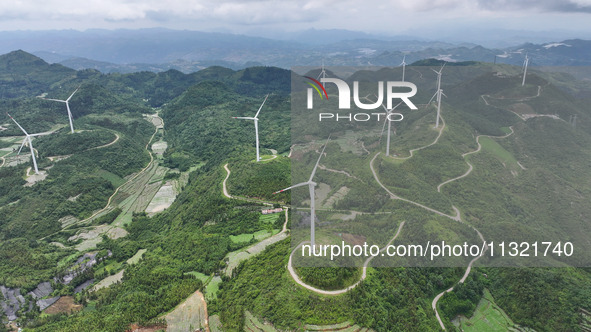 Wind turbines are being seen on a mountain in Qishe township in Xingyi city, Guizhou province, China, on June 11, 2024. 