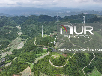 Wind turbines are being seen on a mountain in Qishe township in Xingyi city, Guizhou province, China, on June 11, 2024. (