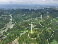 Wind turbines are being seen on a mountain in Qishe township in Xingyi city, Guizhou province, China, on June 11, 2024. (