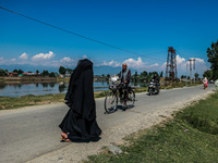 An elderly man is carrying a fan on his bicycle on a hot summer day in Sopore, Baramulla, Jammu and Kashmir, India, on June 11, 2024. (