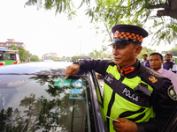 Sitaram Hachhethu, Chief of Lalitpur Metropolitan Police, is pointing to the pollution clearance sticker on the windshield of a vehicle that...