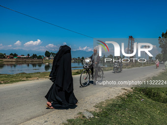 An elderly man is carrying a fan on his bicycle on a hot summer day in Sopore District, Baramulla, Jammu and Kashmir, India, on June 11, 202...