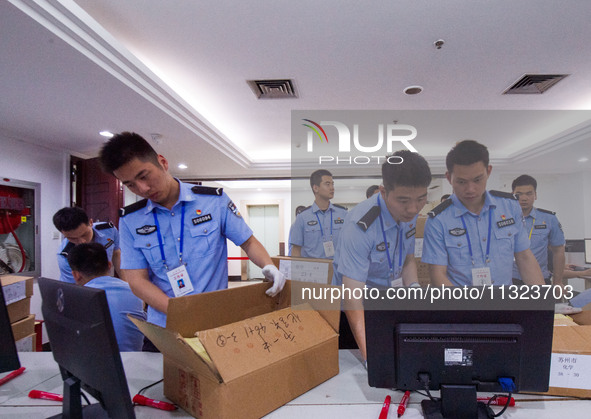 Staff members are performing an orderly scan at a scanning point for the Jiangsu Provincial College Entrance Examination answer sheet in Nan...