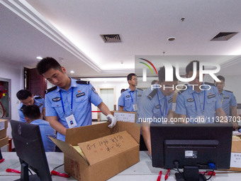 Staff members are performing an orderly scan at a scanning point for the Jiangsu Provincial College Entrance Examination answer sheet in Nan...