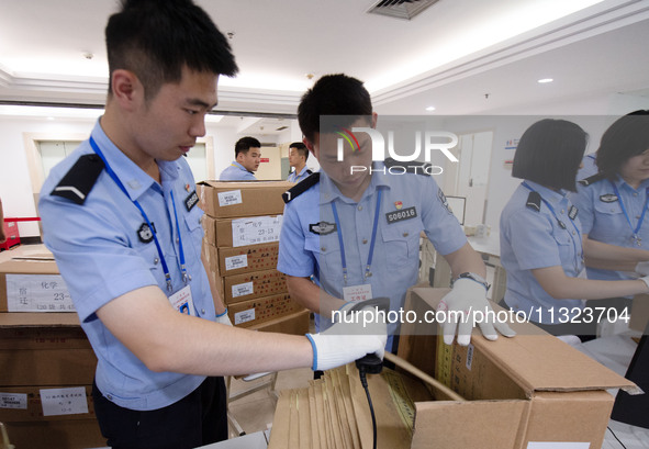 Staff members are performing an orderly scan at a scanning point for the Jiangsu Provincial College Entrance Examination answer sheet in Nan...