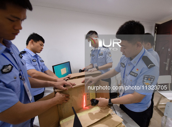 Staff members are performing an orderly scan at a scanning point for the Jiangsu Provincial College Entrance Examination answer sheet in Nan...