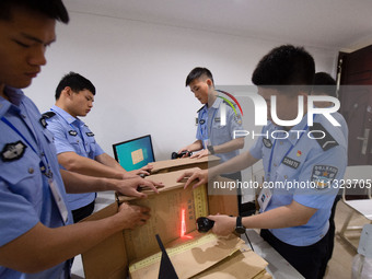 Staff members are performing an orderly scan at a scanning point for the Jiangsu Provincial College Entrance Examination answer sheet in Nan...