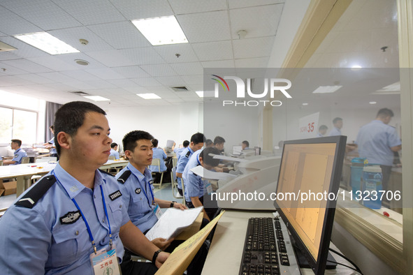 Staff members are performing an orderly scan at a scanning point for the Jiangsu Provincial College Entrance Examination answer sheet in Nan...