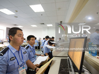 Staff members are performing an orderly scan at a scanning point for the Jiangsu Provincial College Entrance Examination answer sheet in Nan...