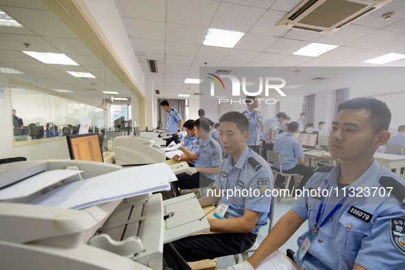 Staff members are performing an orderly scan at a scanning point for the Jiangsu Provincial College Entrance Examination answer sheet in Nan...