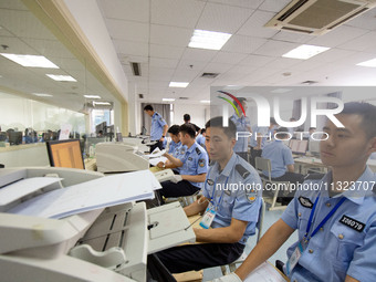 Staff members are performing an orderly scan at a scanning point for the Jiangsu Provincial College Entrance Examination answer sheet in Nan...