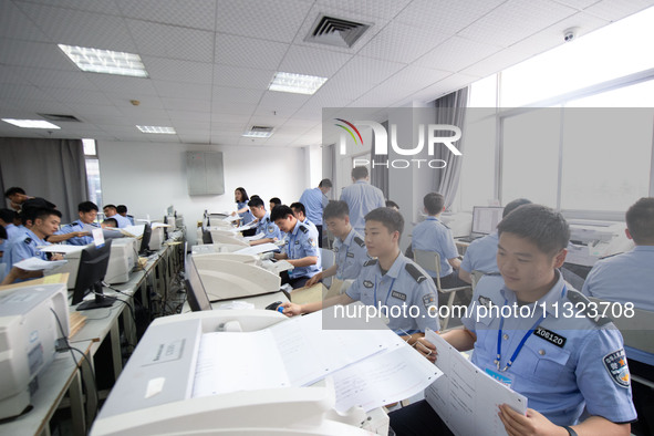 Staff members are performing an orderly scan at a scanning point for the Jiangsu Provincial College Entrance Examination answer sheet in Nan...