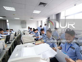 Staff members are performing an orderly scan at a scanning point for the Jiangsu Provincial College Entrance Examination answer sheet in Nan...