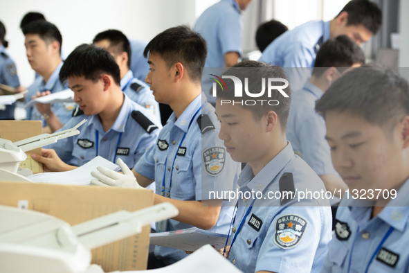 Staff members are performing an orderly scan at a scanning point for the Jiangsu Provincial College Entrance Examination answer sheet in Nan...