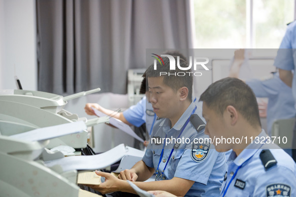 Staff members are performing an orderly scan at a scanning point for the Jiangsu Provincial College Entrance Examination answer sheet in Nan...