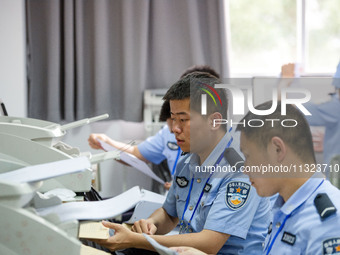 Staff members are performing an orderly scan at a scanning point for the Jiangsu Provincial College Entrance Examination answer sheet in Nan...