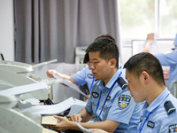 Staff members are performing an orderly scan at a scanning point for the Jiangsu Provincial College Entrance Examination answer sheet in Nan...