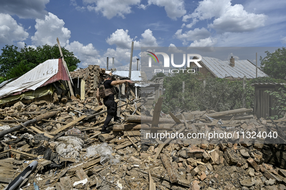 A police officer is recording damage next to a house that is partially destroyed by a Russian drone attack in Orikhiv, Zaporizhzhia region,...