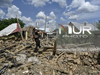 A police officer is recording damage next to a house that is partially destroyed by a Russian drone attack in Orikhiv, Zaporizhzhia region,...